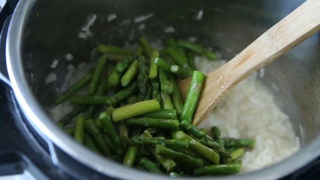 sauteed asparagus on top of cooked risotto in the Instant Pot