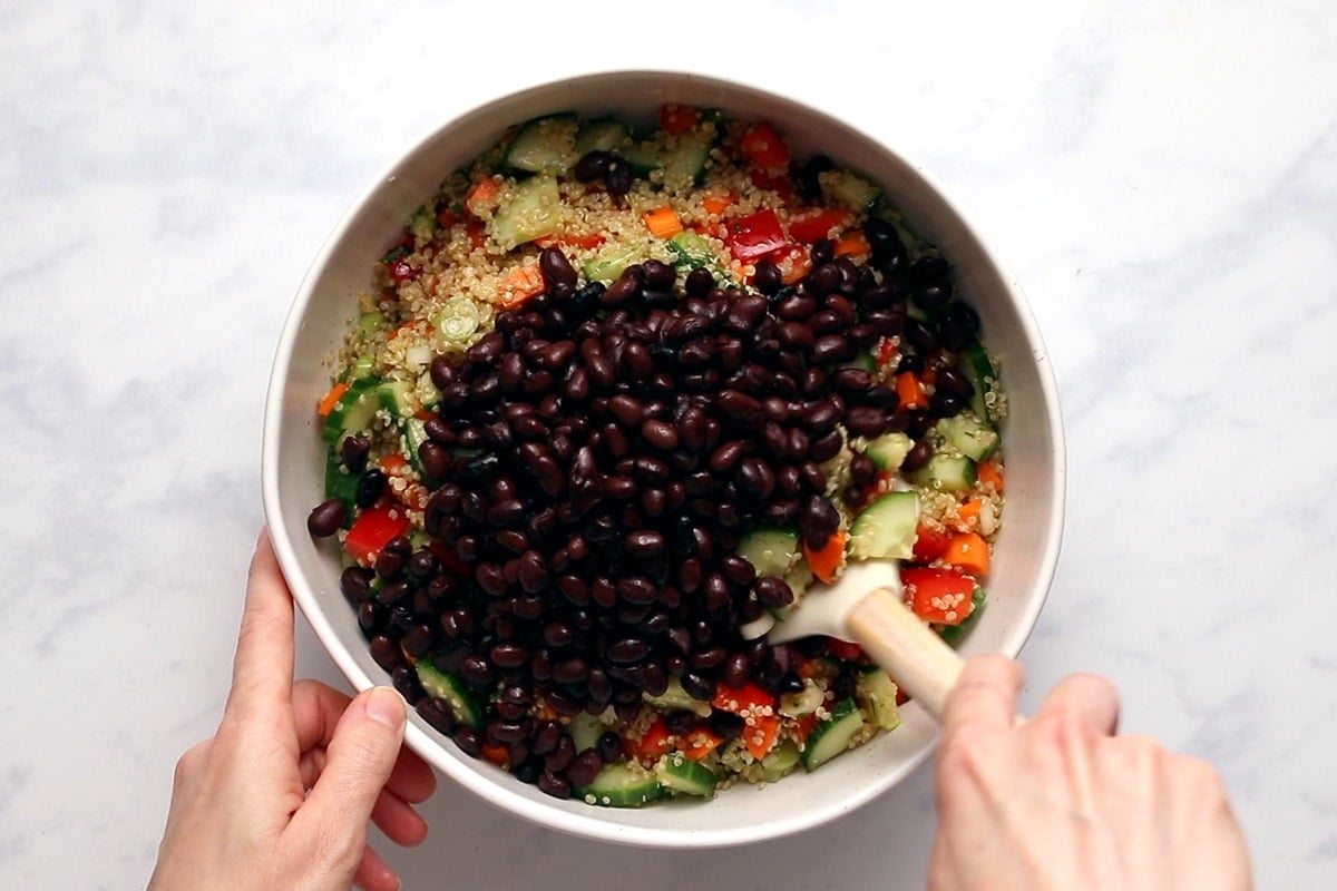 ingredients for quinoa black bean salad together in a large glass bowl