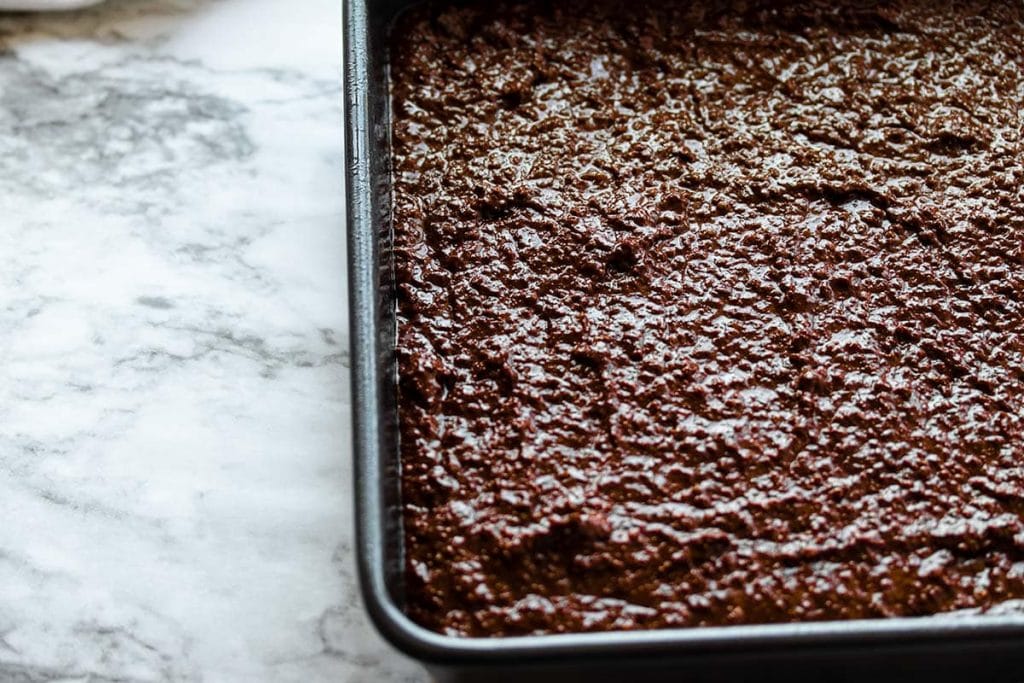 quinoa brownie cake batter in a metal brownie pan