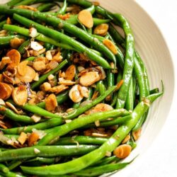Green beans in almondine in a white serving dish