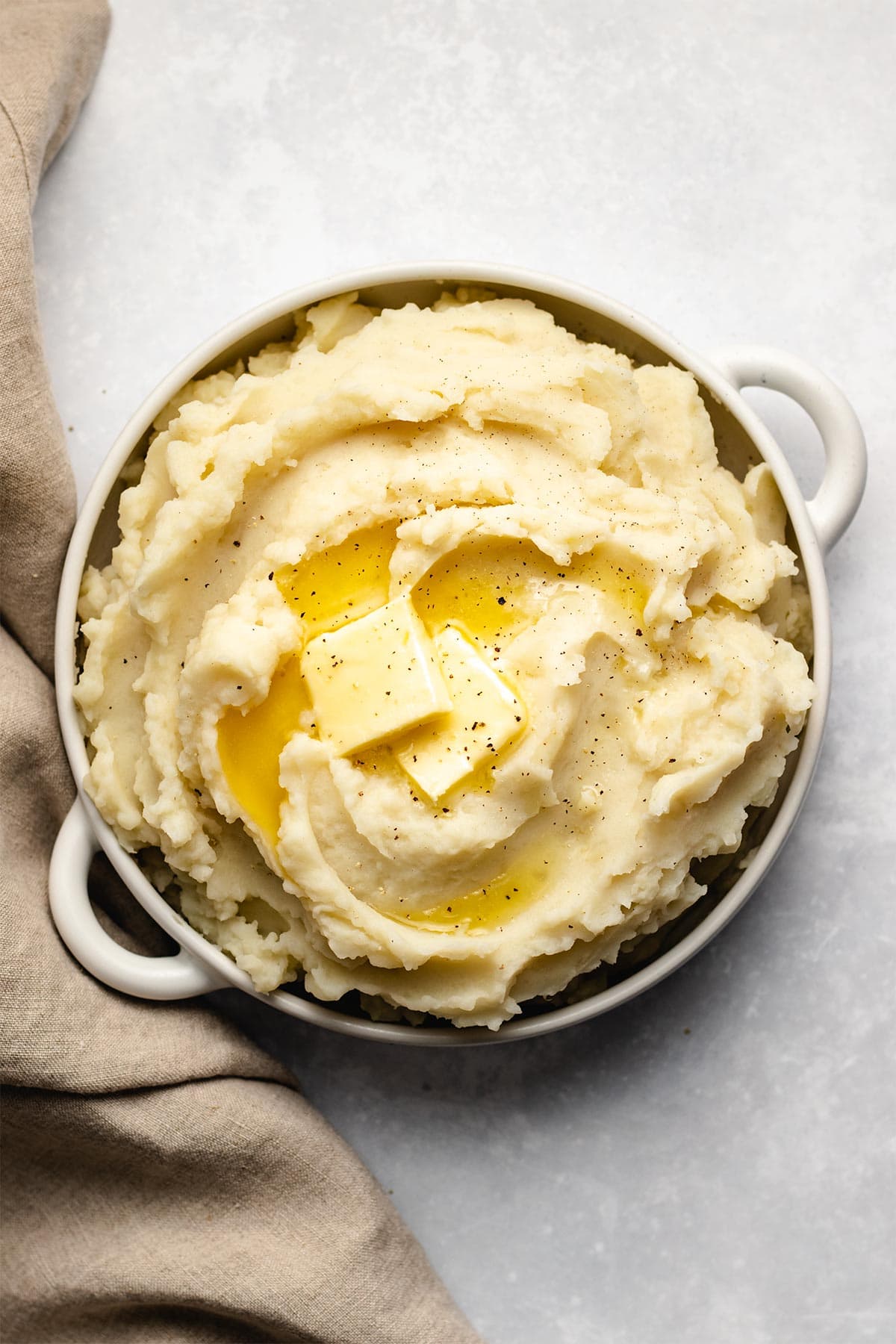 Butter melting on mashed potatoes in a white bowl
