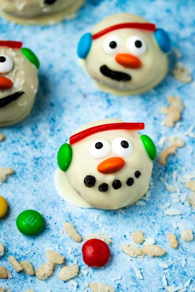 a snowman peanut butter ball in front of a group of other snowman peanut butter balls