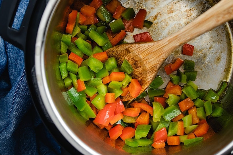 diced green and red bell pepper being sautéed in an Instant Pot