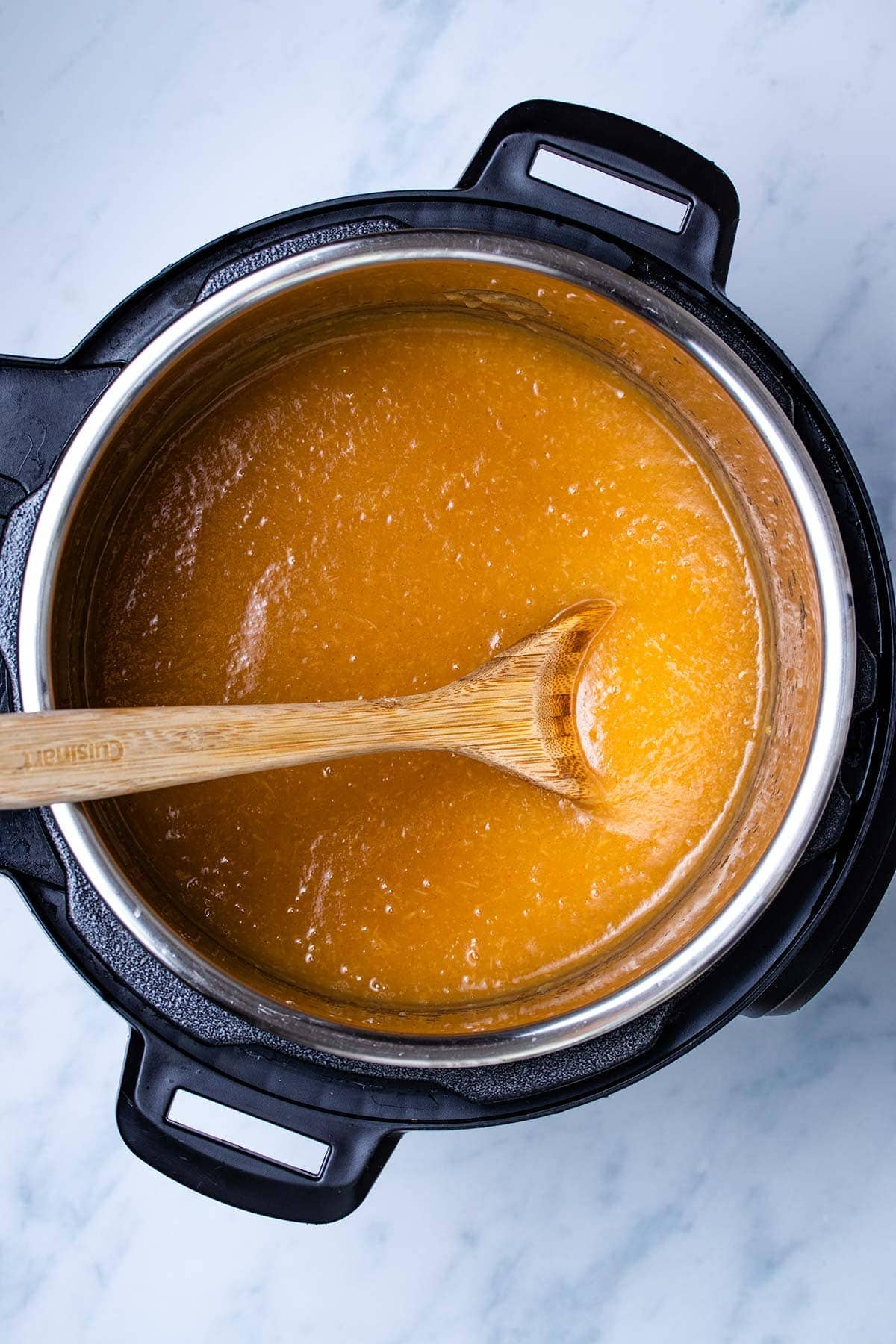 applesauce in an Instant Pot with a wooden spoon