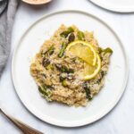 Instant Pot Lemon Asparagus Risotto on a white plate garnished with parmesan cheese and lemon slices
