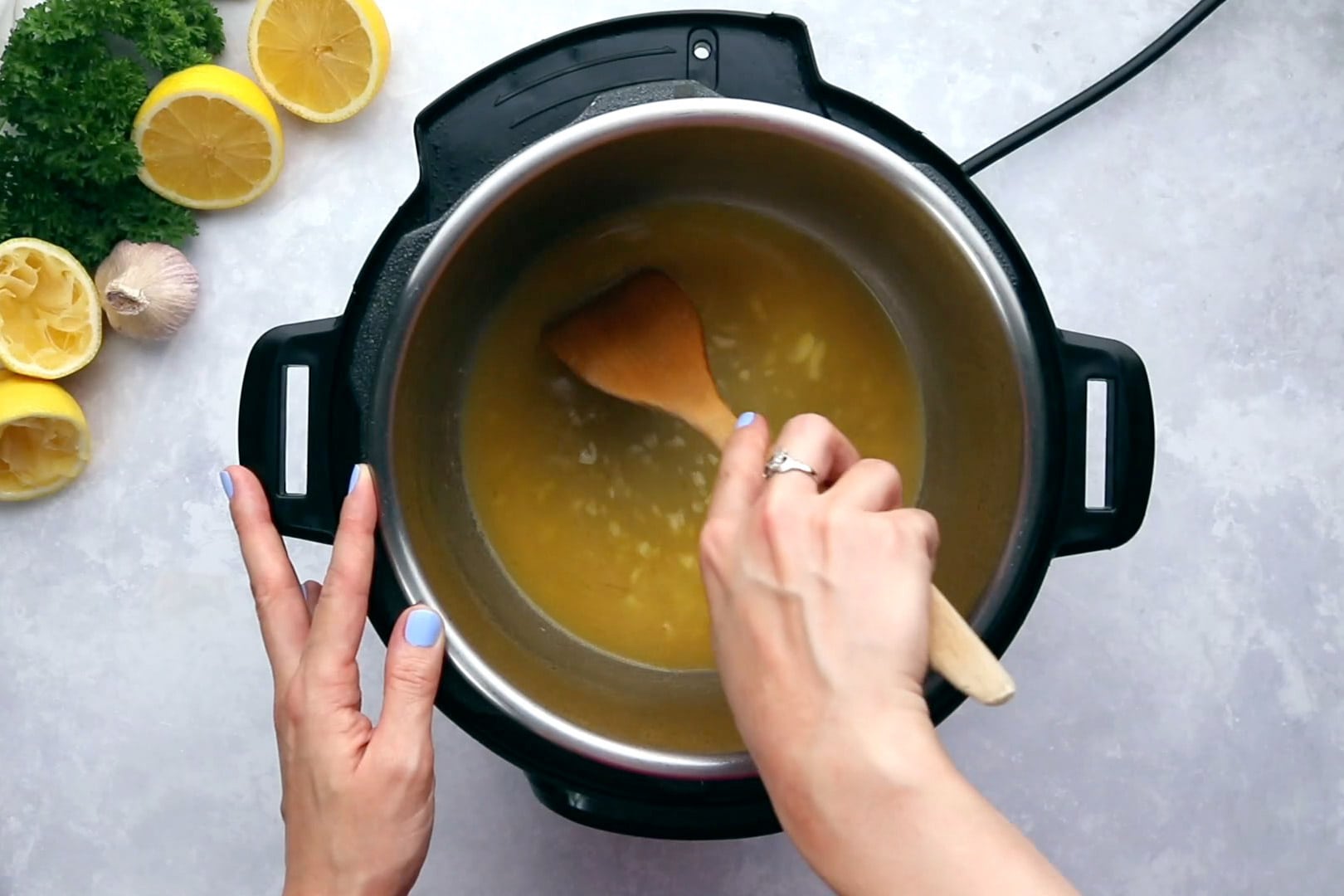 deglazing the bottom of an Instant Pot liner using a wooden turner