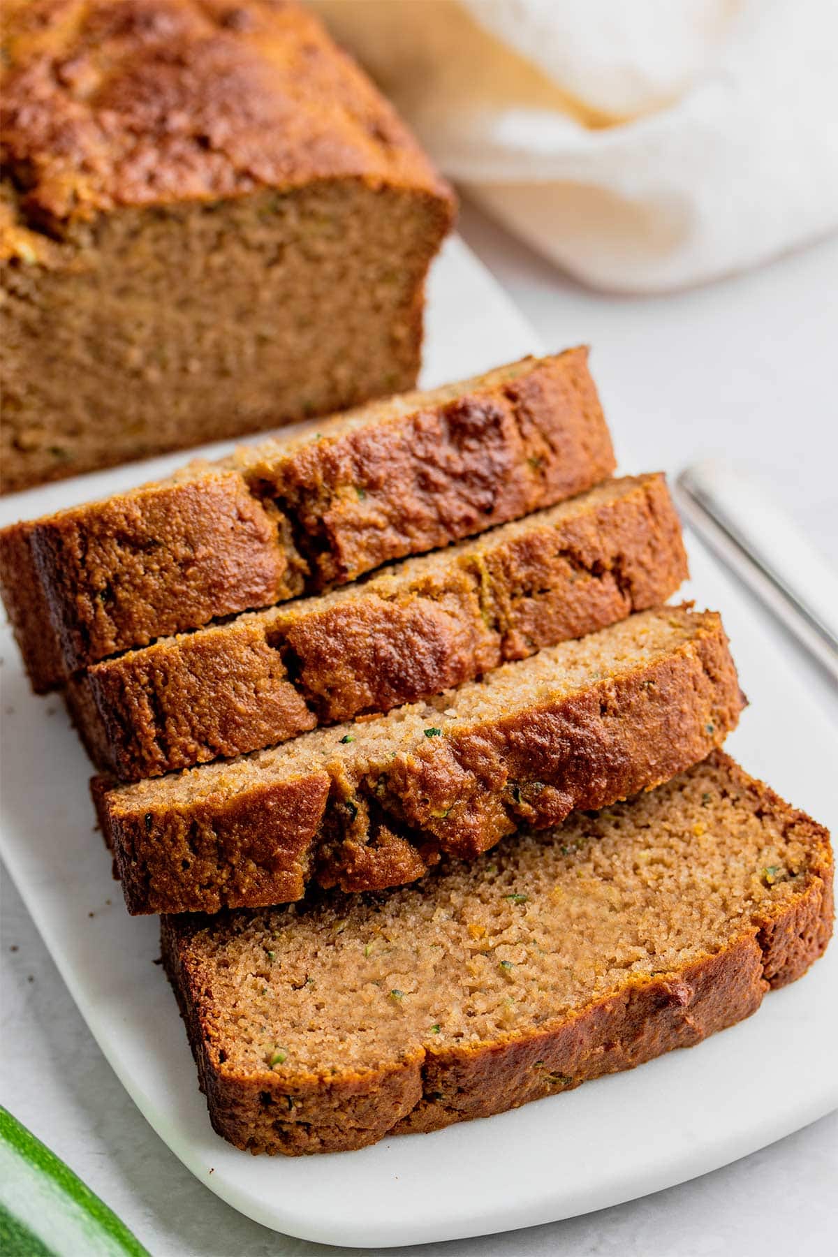 Slices of almond flour zucchini bread on a white marble serving tray