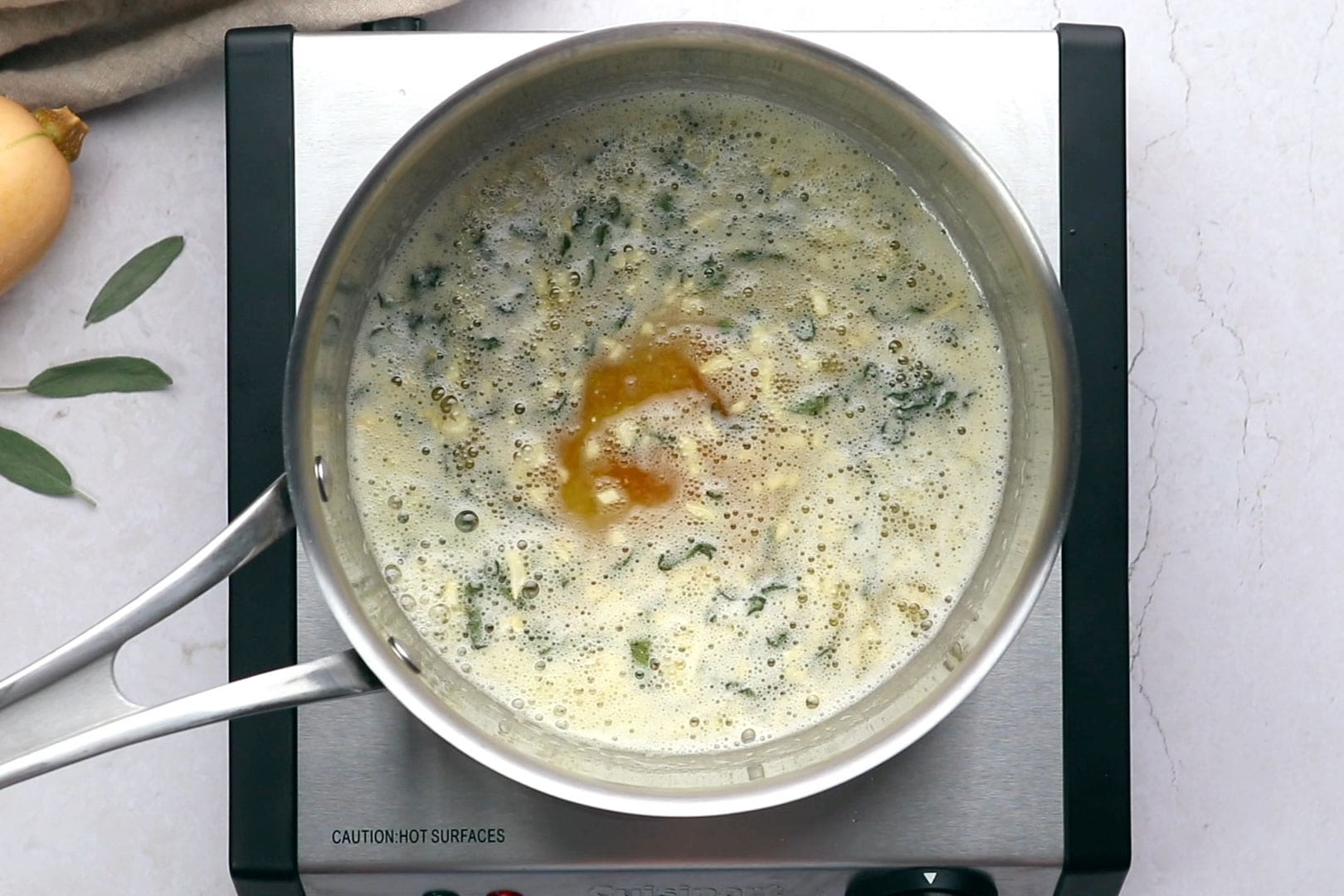 brown butter sage sauce in a silver sauce pan on a single burner