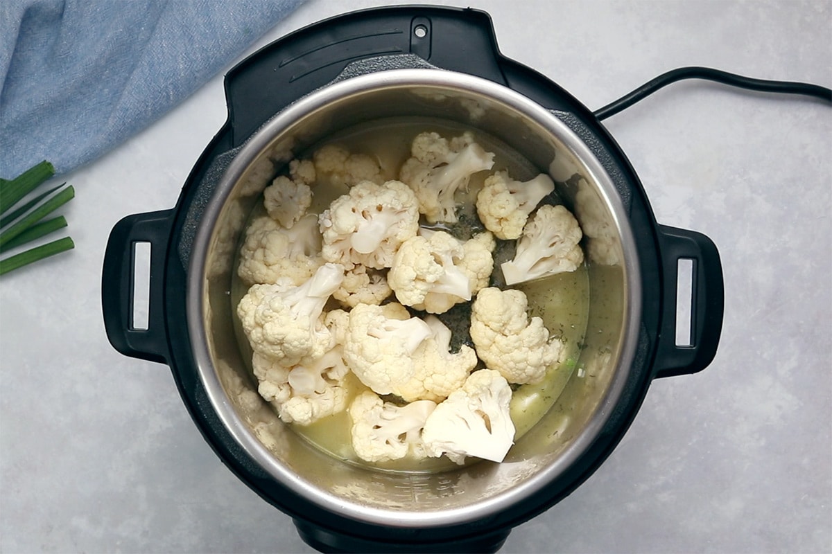 Uncooked cauliflower florets in an Instant Pot viewed from overhead.