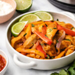 Instant Pot Chicken Fajitas in a white bowl with handles.