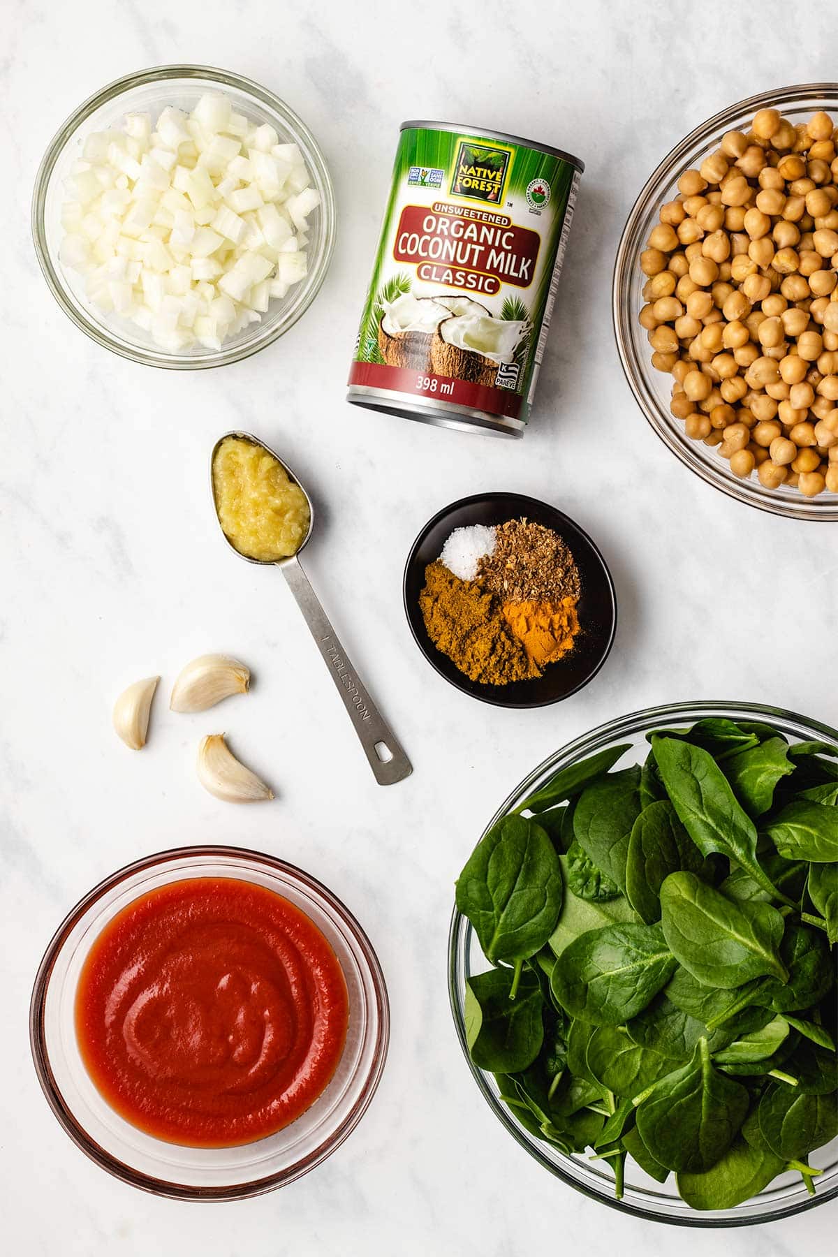 Ingredients needed to make chickpea spinach curry viewed from overhead.