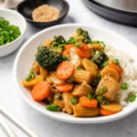 Instant Pot Chicken Stir Fry served with rice on a white plate.