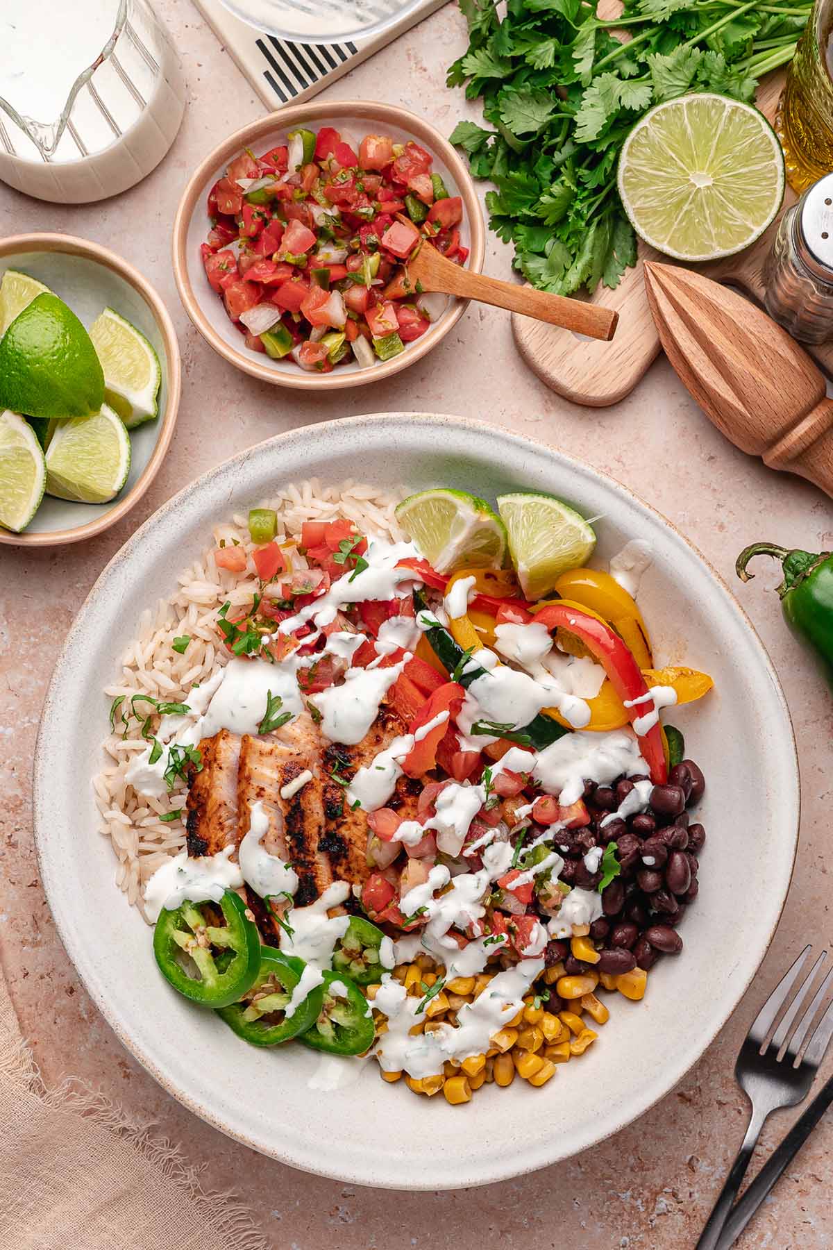 Overhead chicken fajita bowl with grilled chicken, bell peppers, black beans, corn, pico de gallo, and jalapeño slices.