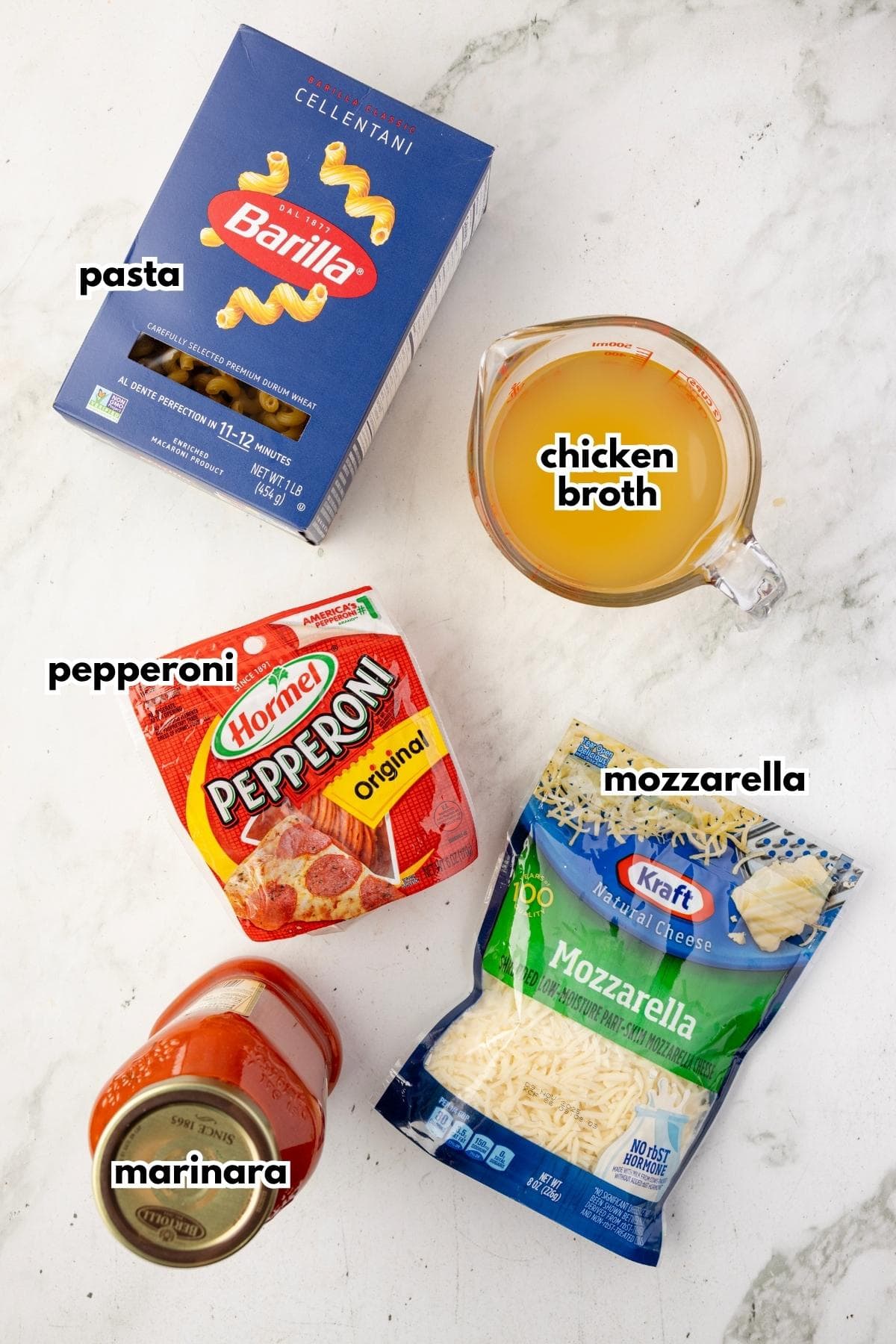 Labeled ingredients for pizza pasta bake: cellentani pasta, chicken broth, pepperoni, mozzarella, and marinara.